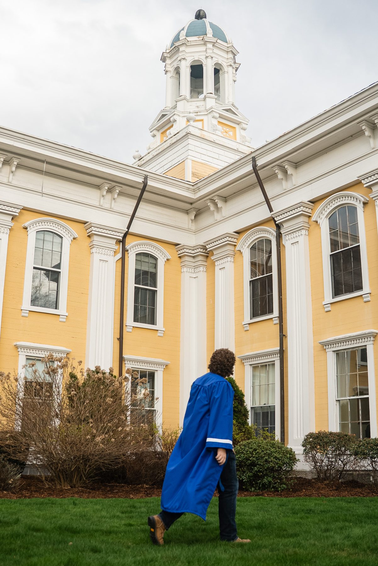 Crossing campus in cap and gown